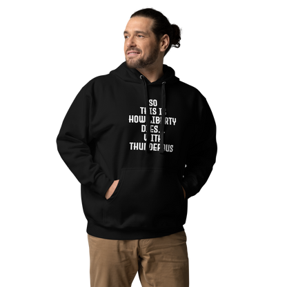 "So this is how liberty dies… with thunderous applause" printed on a black unisex hoodie worn by a male