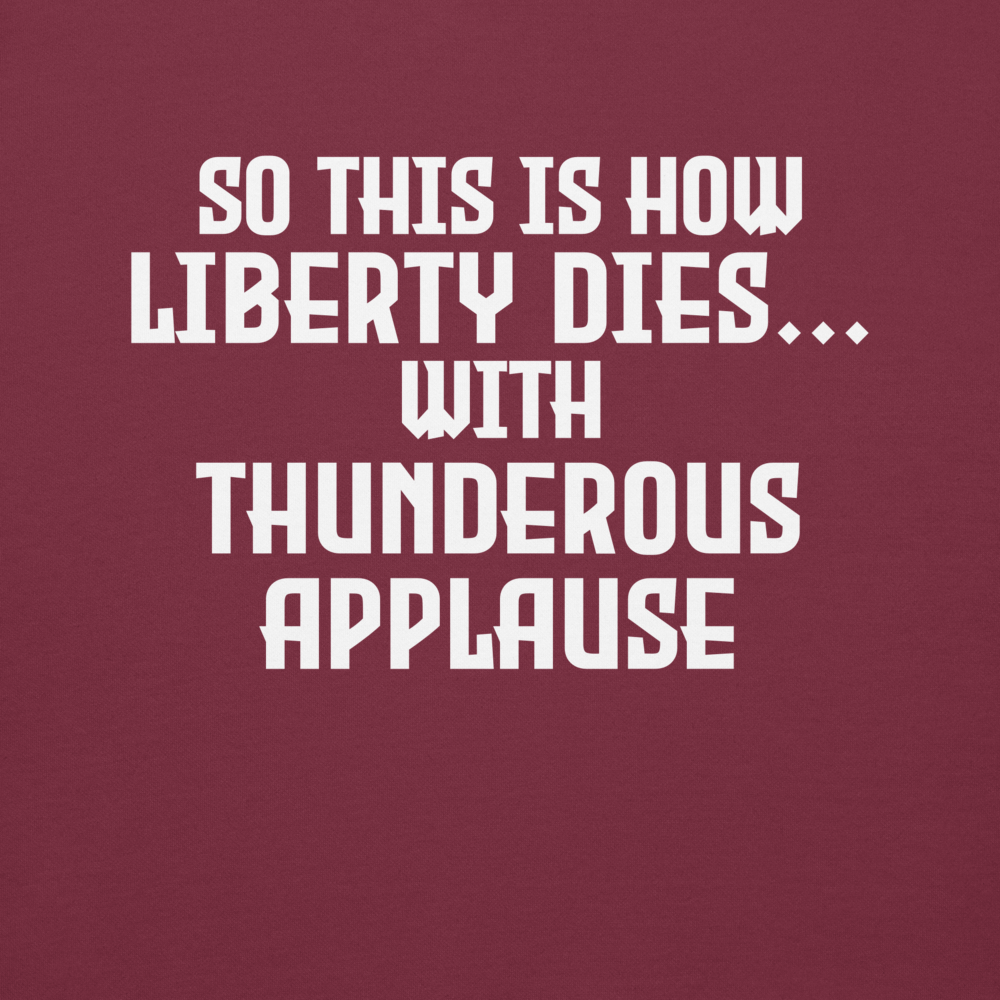"So this is how liberty dies… with thunderous applause" printed on a maroon background