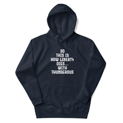 "So this is how liberty dies… with thunderous applause" printed on a navy blazer unisex hoodie laying on a flat surface with the hood up