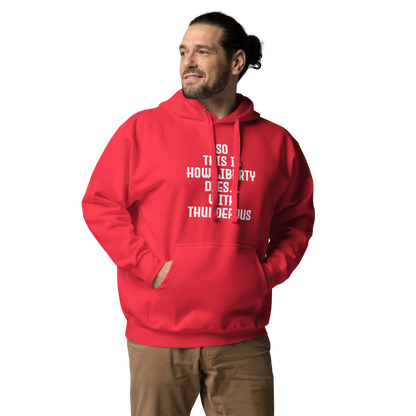 "So this is how liberty dies… with thunderous applause" printed on a team red unisex hoodie worn by a male