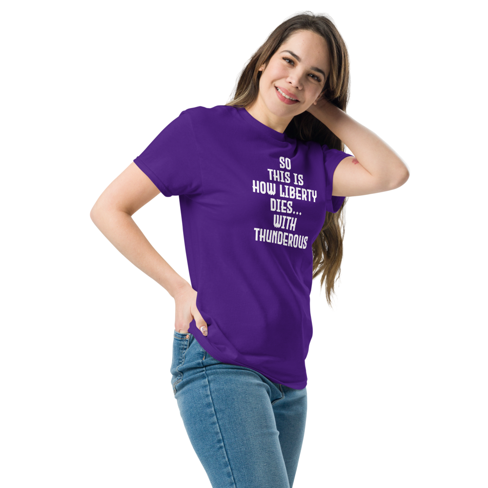"So this is how liberty dies… with thunderous applause" printed on a purple unisex classic tee worn by a female
