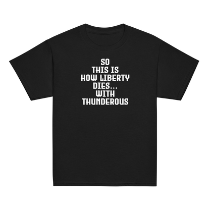 "So this is how liberty dies… with thunderous applause" printed on a black youth classic tee laying on a flat surface