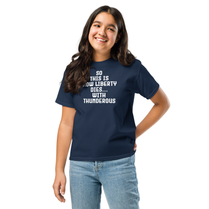 "So this is how liberty dies… with thunderous applause" printed on a navy youth classic tee worn by a female