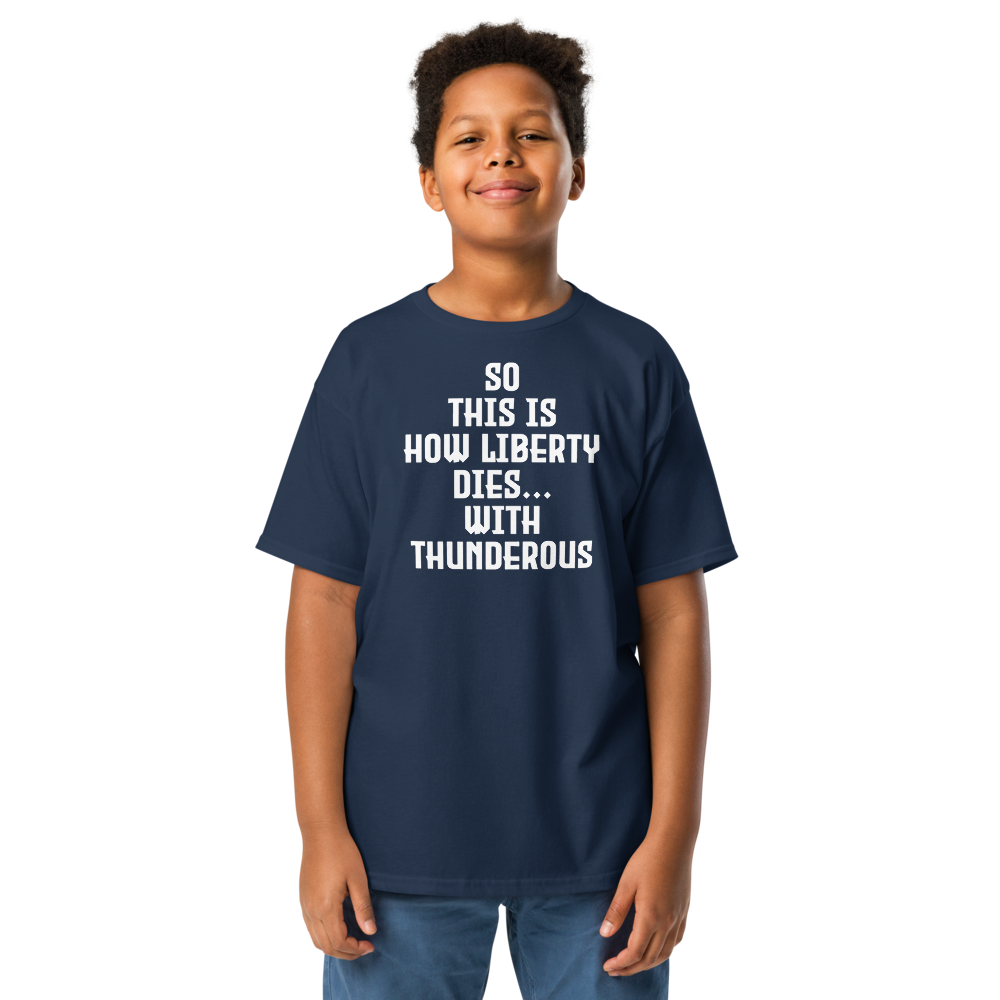 "So this is how liberty dies… with thunderous applause" printed on a navy youth classic tee worn by a male