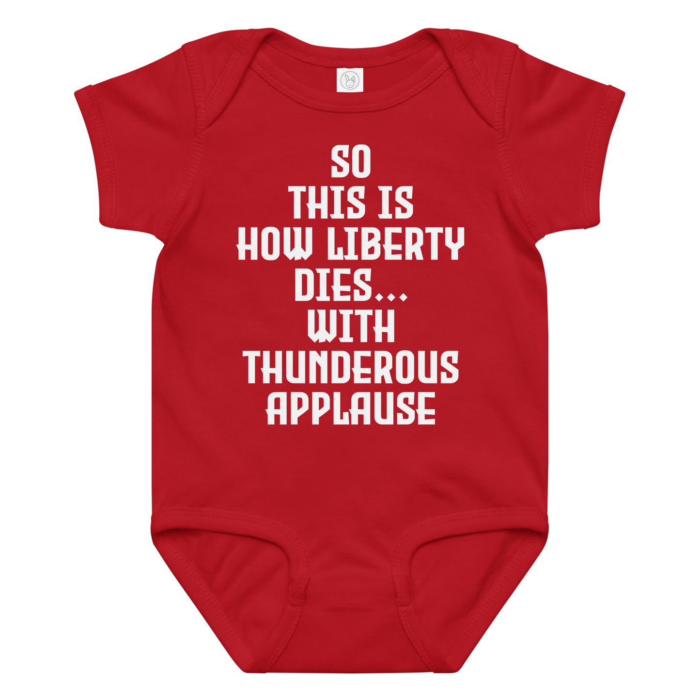 "So this is how liberty dies… with thunderous applause" printed on a red baby jersey bodysuit laying on a flat surface amongst other clothes