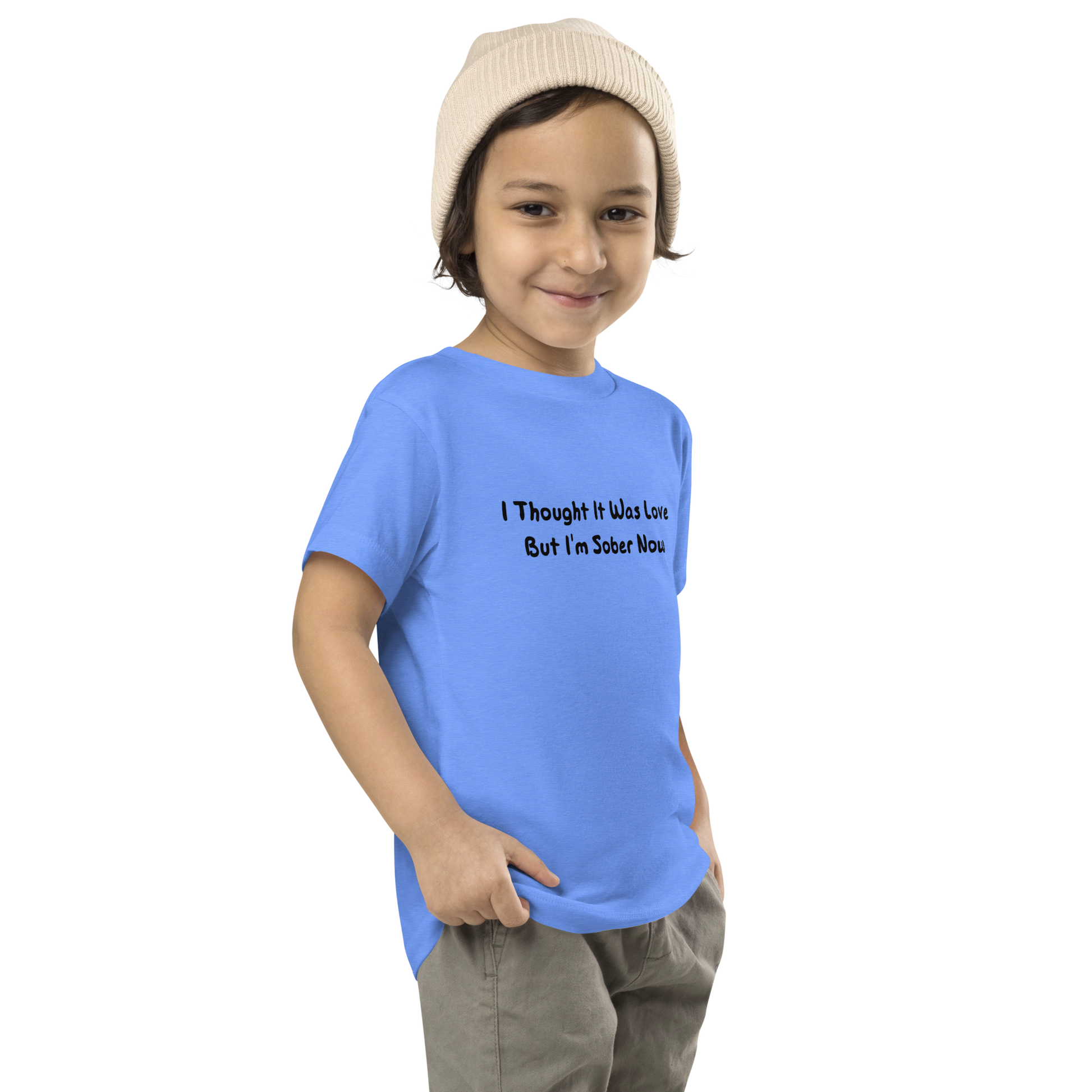 "I thought it was love but I’m sober now" printed on a heather columbia blue toddler short sleeve tee worn by a male who is also wearing a knit cap
