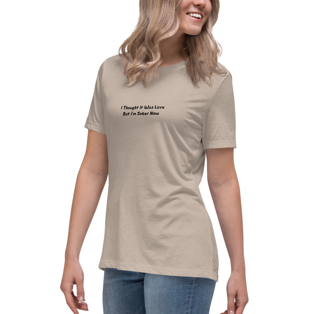 "I thought it was love but I’m sober now" printed on a heather stone women's relaxed t-shirt worn by a female