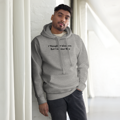 "I thought it was love but I’m sober now" printed on a carbon grey unisex hoodie worn by a male