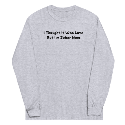 "I thought it was love but I’m sober now" printed on a sport grey men's long sleeve shirt laying on a flat surface