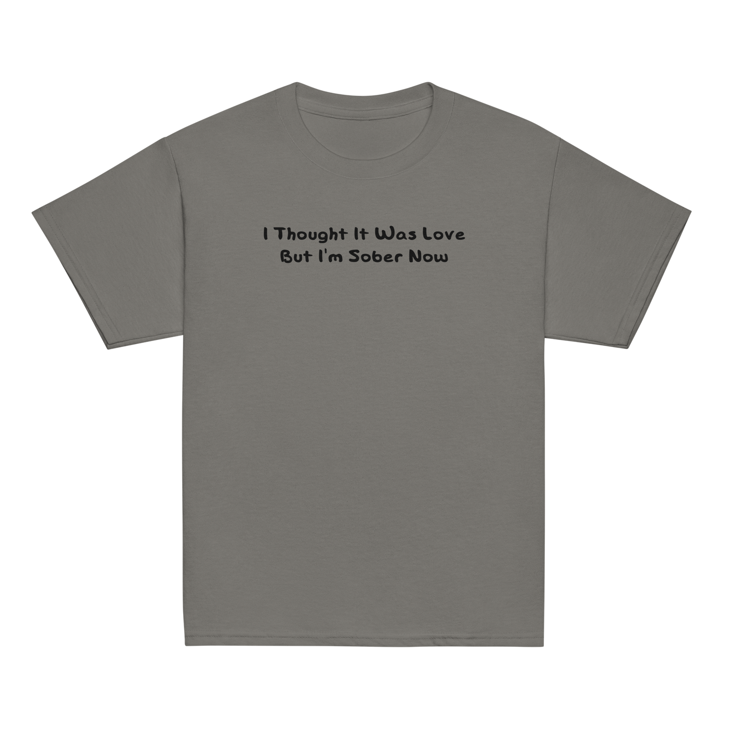 "I thought it was love but I’m sober now" printed on a charcoal youth classic tee laying on a flat surface