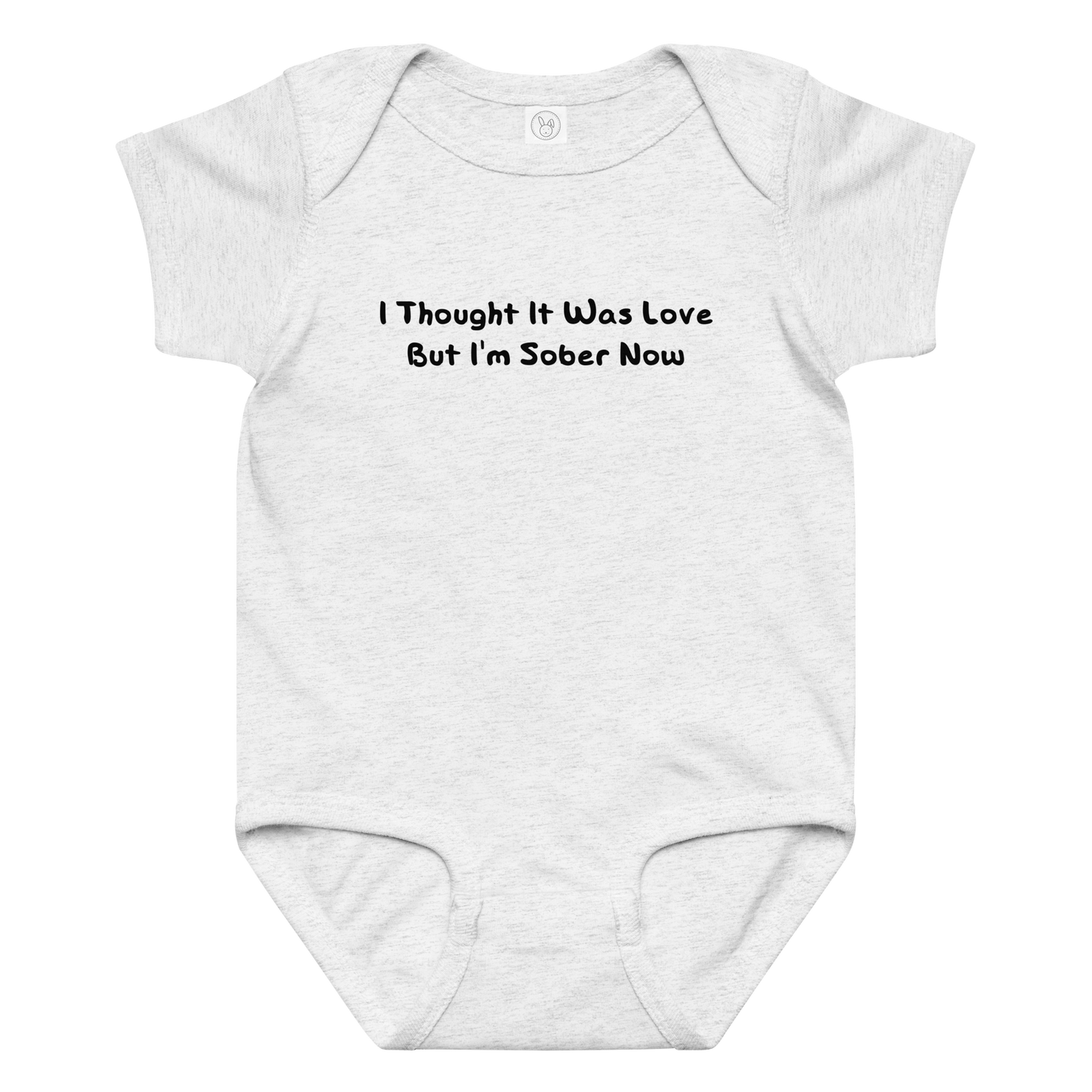 "I thought it was love but I’m sober now" printed on a ash baby jersey bodysuit laying on a flat surface amongst other clothes