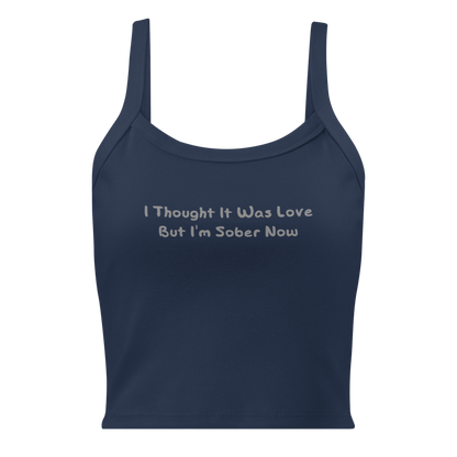 "I thought it was love but I’m sober now" printed on a solid navy blend women's micro-rib tanktop laying on a flat surface