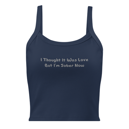 "I thought it was love but I’m sober now" printed on a solid navy blend women's micro-rib tanktop laying on a flat surface
