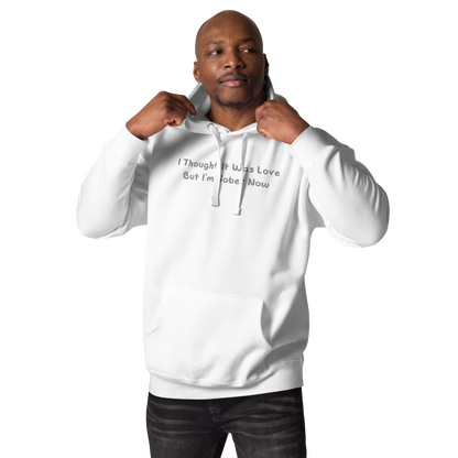 "I thought it was love but I’m sober now" printed on a white unisex hoodie worn by a male