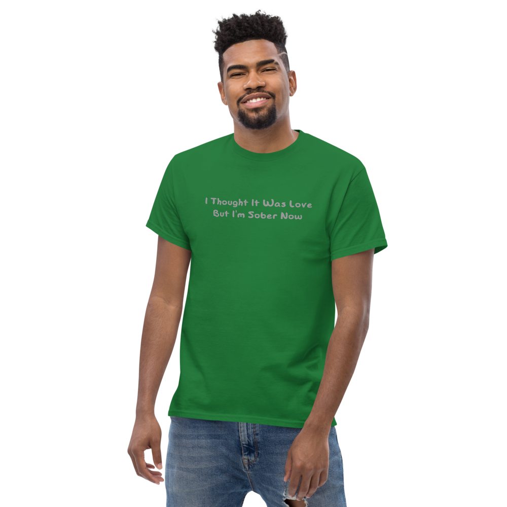 "I thought it was love but I’m sober now" printed on a turf green unisex classic tee worn by a male