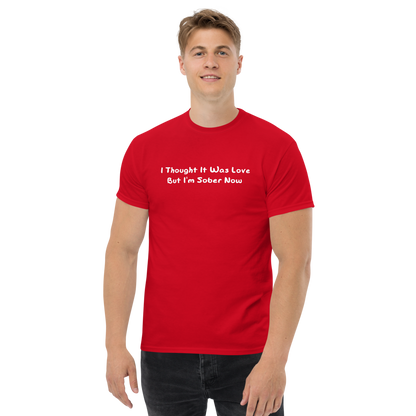 "I thought it was love but I’m sober now" printed on a red unisex classic tee worn by a male