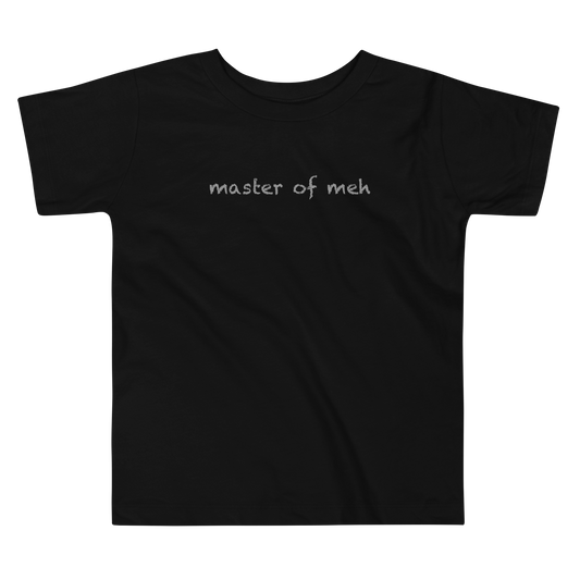 "Master of meh" printed on a black toddler short sleeve tee laying on a flat surface