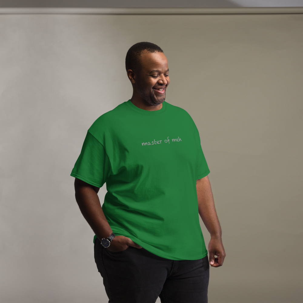 "Master of meh" printed on a turf green unisex classic tee worn by a male