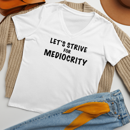 "Let's strive for mediocity" printed on a solid white blend women's relaxed v-neck t-shirt laying on a flat surface amongst other clothes