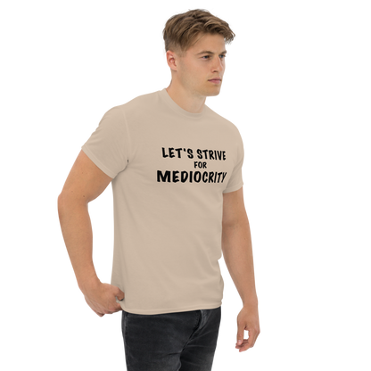 "Let's strive for mediocity" printed on a sand unisex classic tee worn by a male
