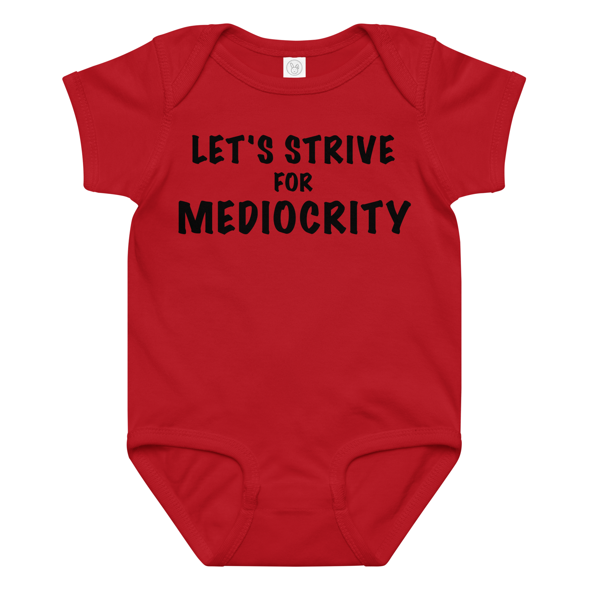 "Let's strive for mediocity" printed on a red baby jersey bodysuit laying on a flat surface amongst other clothes
