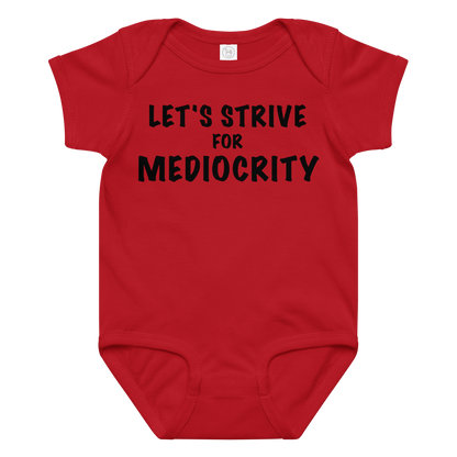 "Let's strive for mediocity" printed on a red baby jersey bodysuit laying on a flat surface amongst other clothes