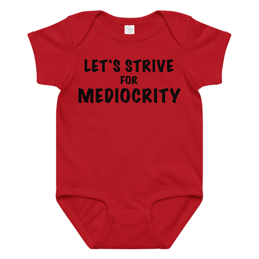 "Let's strive for mediocity" printed on a red baby jersey bodysuit laying on a flat surface amongst other clothes