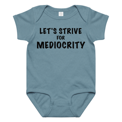 "Let's strive for mediocity" printed on a vintage indigo baby jersey bodysuit laying on a flat surface amongst other clothes