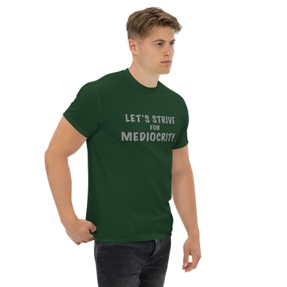 "Let's strive for mediocity" printed on a forest green unisex classic tee worn by a male