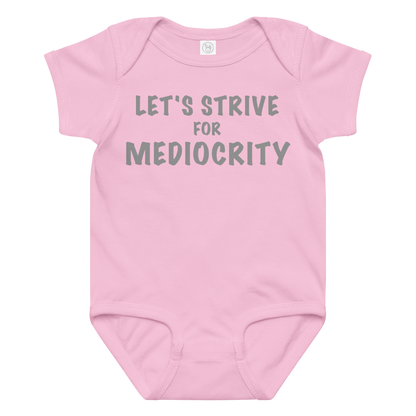"Let's strive for mediocity" printed on a pink baby jersey bodysuit laying on a flat surface amongst other clothes