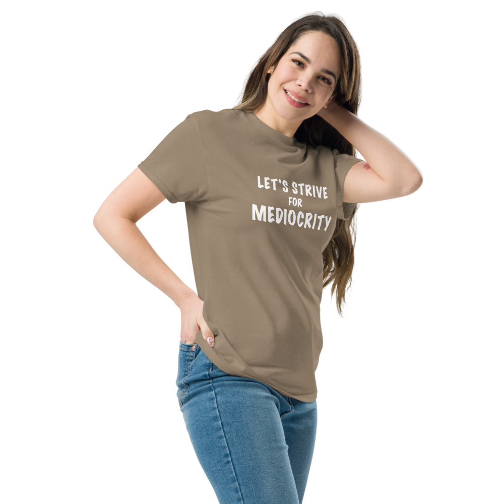 "Let's strive for mediocity" printed on a brown savana unisex classic tee worn by a female