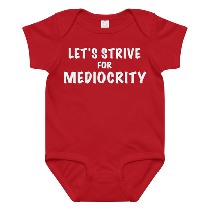 "Let's strive for mediocity" printed on a red baby jersey bodysuit laying on a flat surface amongst other clothes