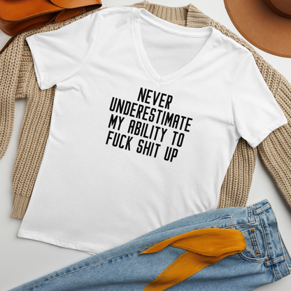 "Never Understimate My Ability To Fuck Shit Up" printed on a solid white blend women's relaxed v-neck t-shirt laying on a flat surface amongst other clothes