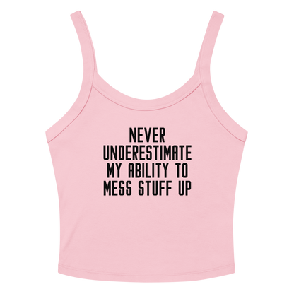 "Never Understimate My Ability To Mess Stuff Up" printed on a solid pink blend women's micro-rib tanktop laying on a flat surface amongst sunglasses and shorts