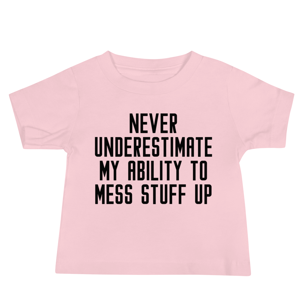 "Never Understimate My Ability To Mess Stuff Up" printed on a pink baby jersey short sleeve tee laying on a flat surface