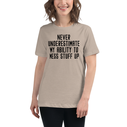 "Never Understimate My Ability To Mess Stuff Up" printed on a heather stone women's relaxed t-shirt worn by a female
