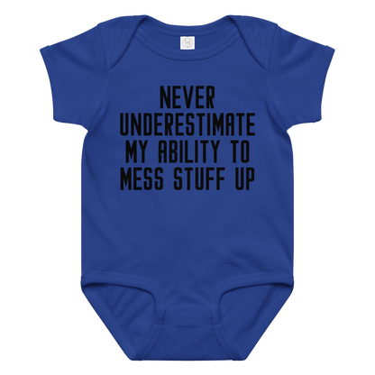 "Never Understimate My Ability To Mess Stuff Up" printed on a royal baby jersey bodysuit laying on a flat surface amongst other clothes