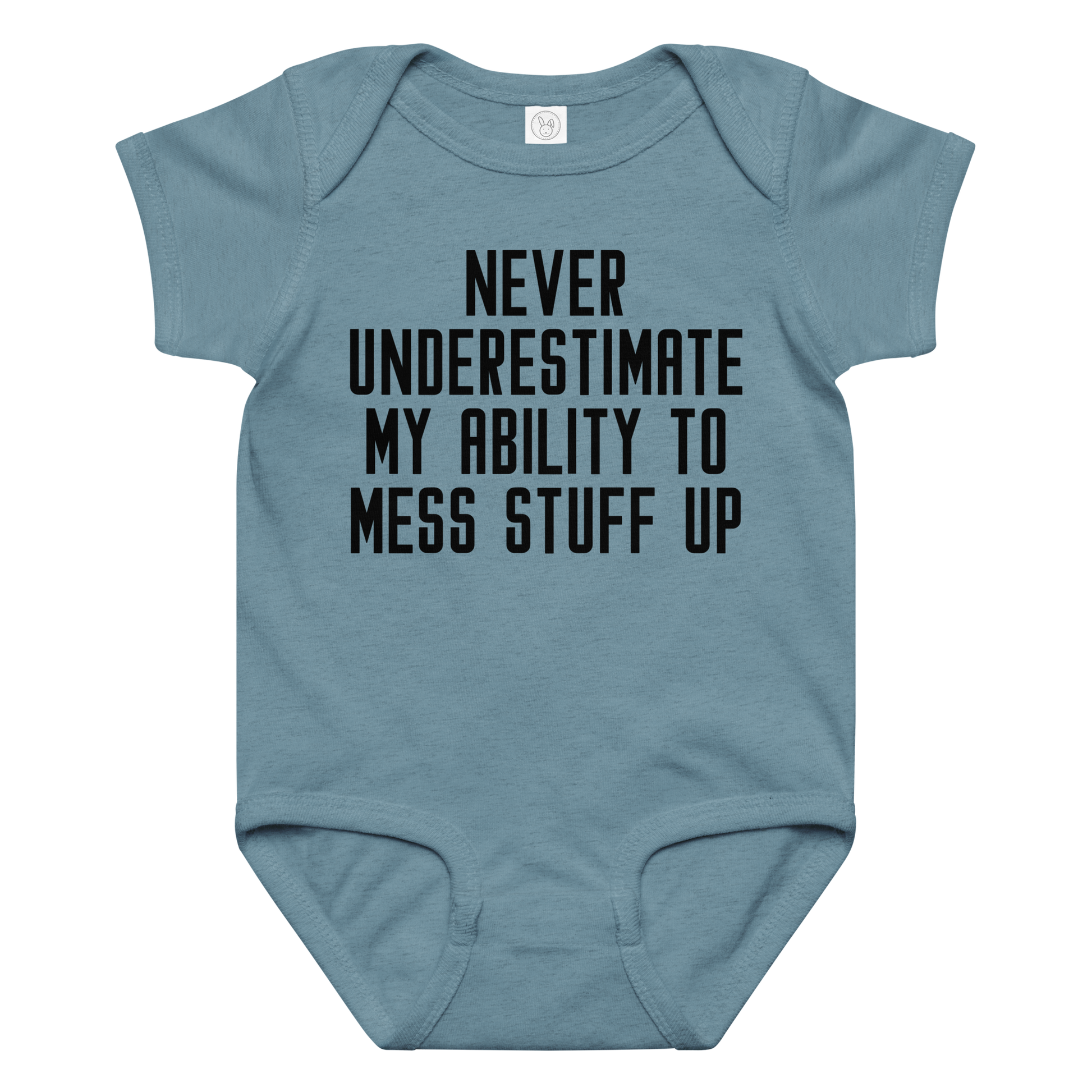 "Never Understimate My Ability To Mess Stuff Up" printed on a vintage indigo baby jersey bodysuit laying on a flat surface amongst other clothes