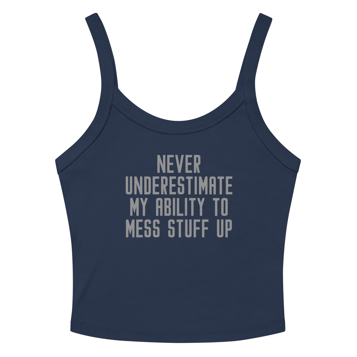 "Never Understimate My Ability To Mess Stuff Up" printed on a solid navy blend women's micro-rib tanktop laying on a flat surface amongst sunglasses and shorts