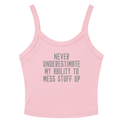 "Never Understimate My Ability To Mess Stuff Up" printed on a solid pink blend women's micro-rib tanktop laying on a flat surface amongst sunglasses and shorts