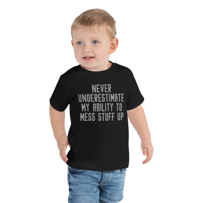 "Never Understimate My Ability To Mess Stuff Up" printed on a black toddler short sleeve tee worn by a male