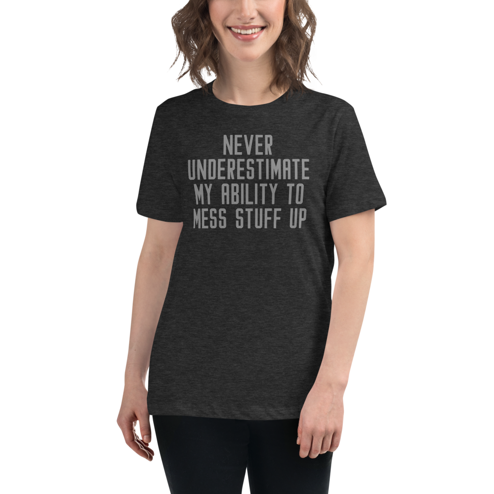 "Never Understimate My Ability To Mess Stuff Up" printed on a dark grey heather women's relaxed t-shirt worn by a female