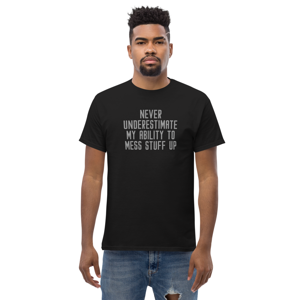 "Never Understimate My Ability To Mess Stuff Up" printed on a black unisex classic tee worn by a male