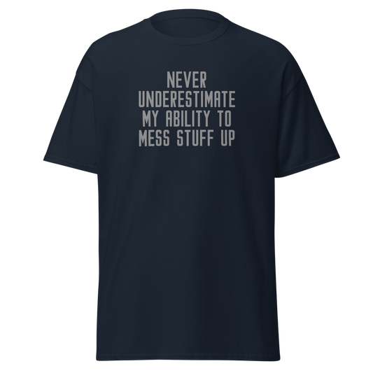 "Never Understimate My Ability To Mess Stuff Up" printed on a navy unisex classic tee laying on a flat surface
