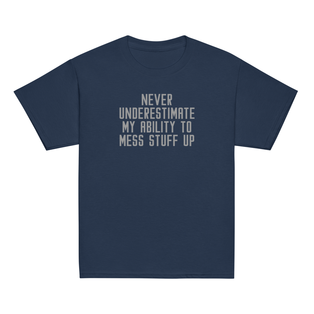 "Never Understimate My Ability To Mess Stuff Up" printed on a navy youth classic tee laying on a flat surface