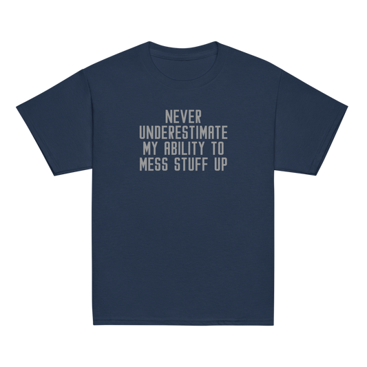 "Never Understimate My Ability To Mess Stuff Up" printed on a navy youth classic tee laying on a flat surface