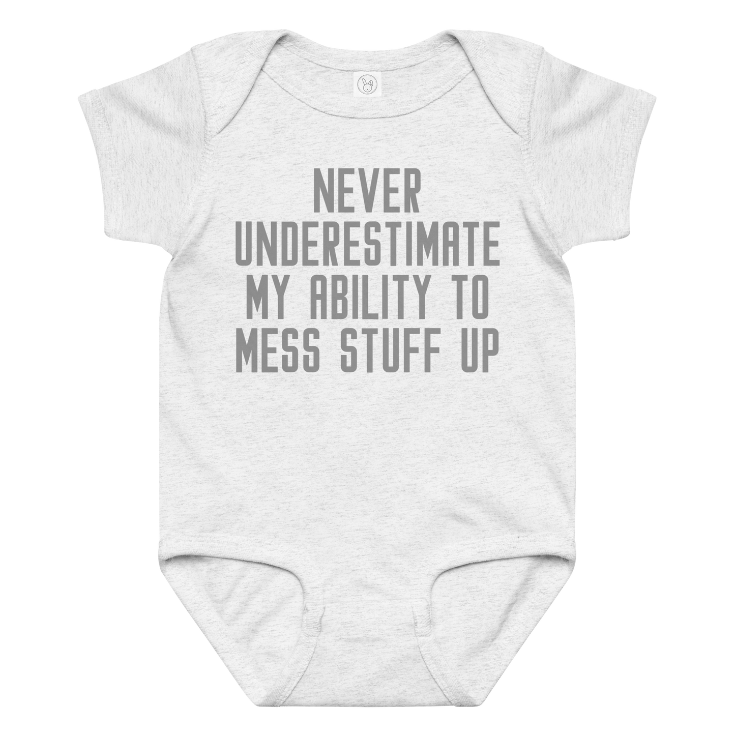 "Never Understimate My Ability To Mess Stuff Up" printed on a ash baby jersey bodysuit laying on a flat surface amongst other clothes