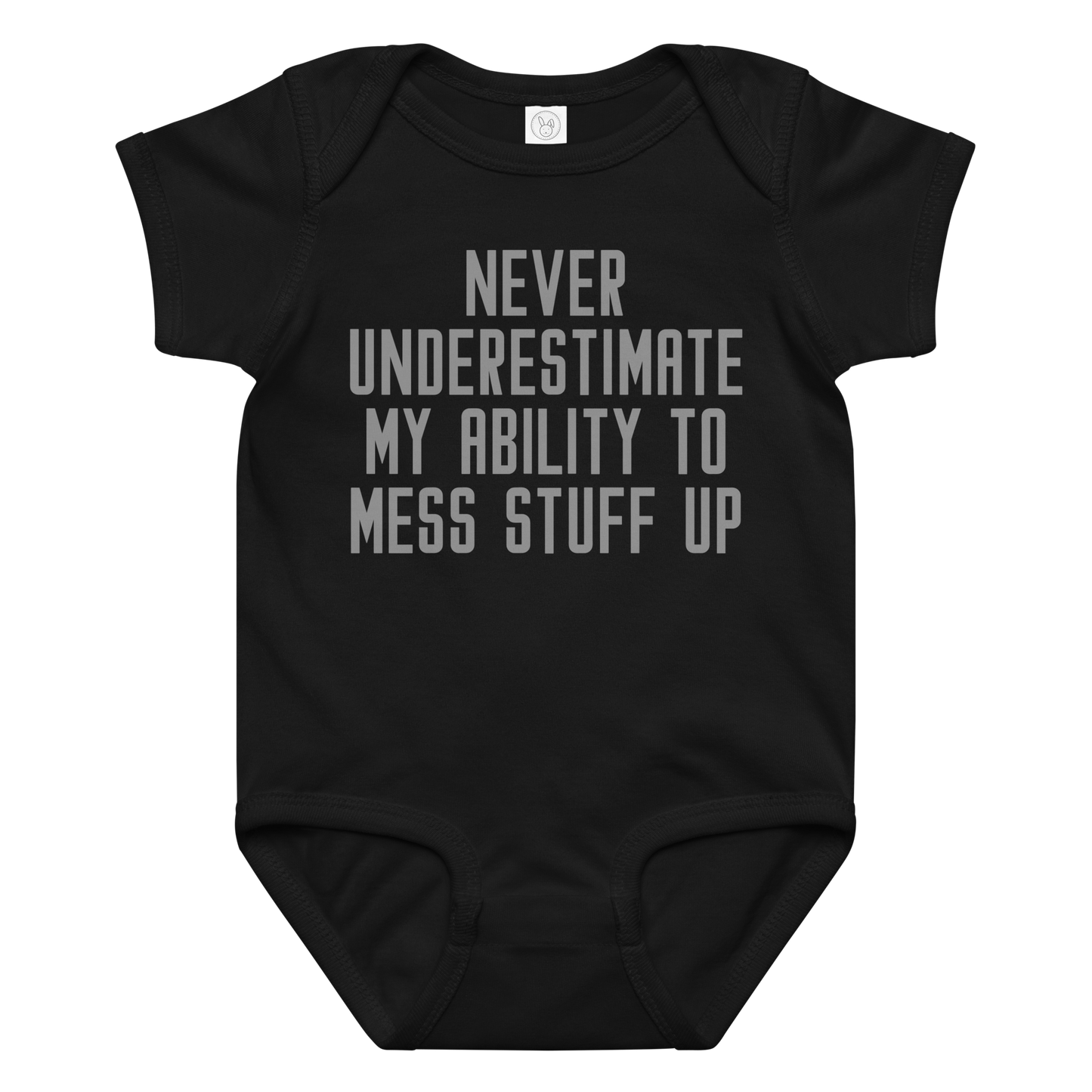 "Never Understimate My Ability To Mess Stuff Up" printed on a black baby jersey bodysuit laying on a flat surface amongst other clothes