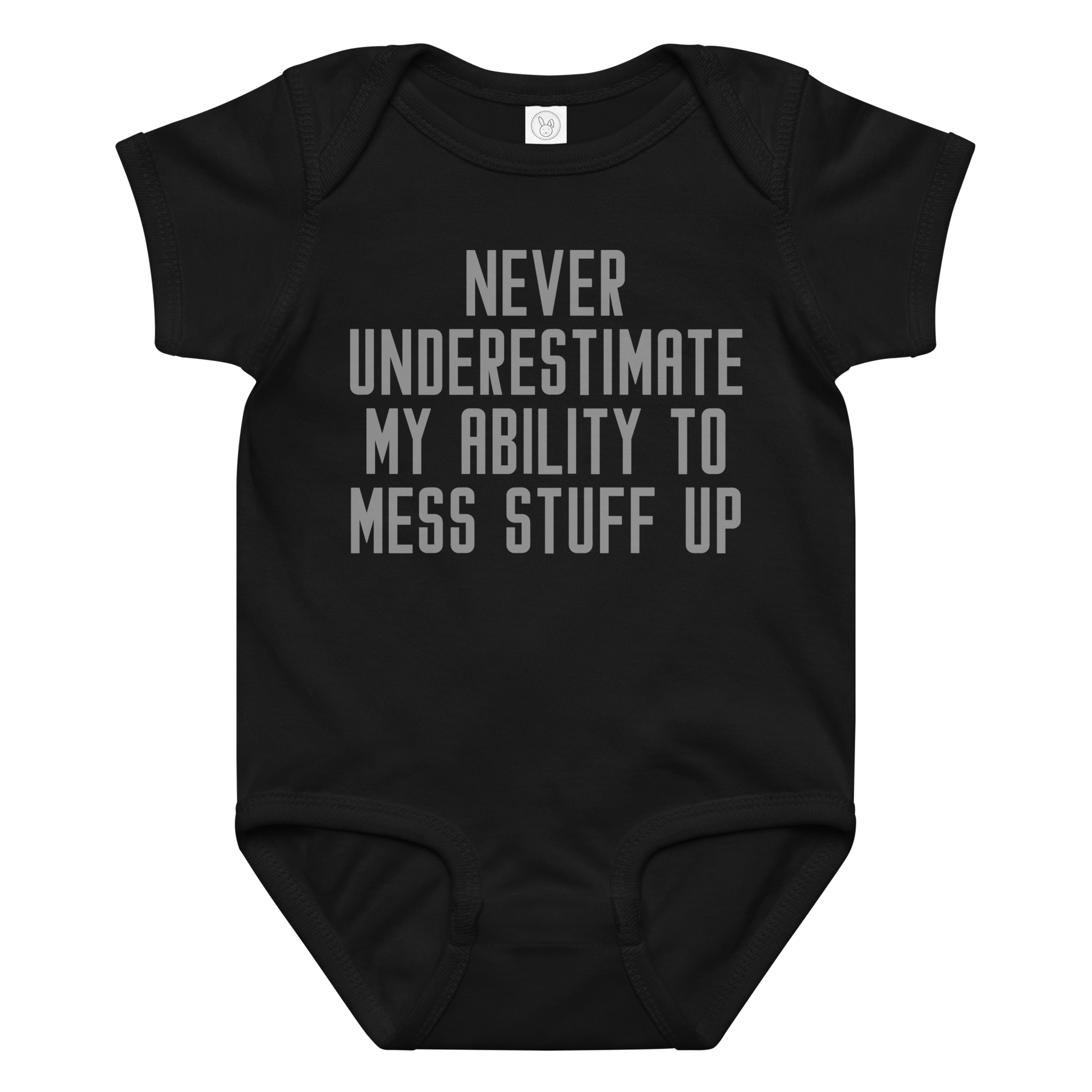 "Never Understimate My Ability To Mess Stuff Up" printed on a black baby jersey bodysuit laying on a flat surface amongst other clothes