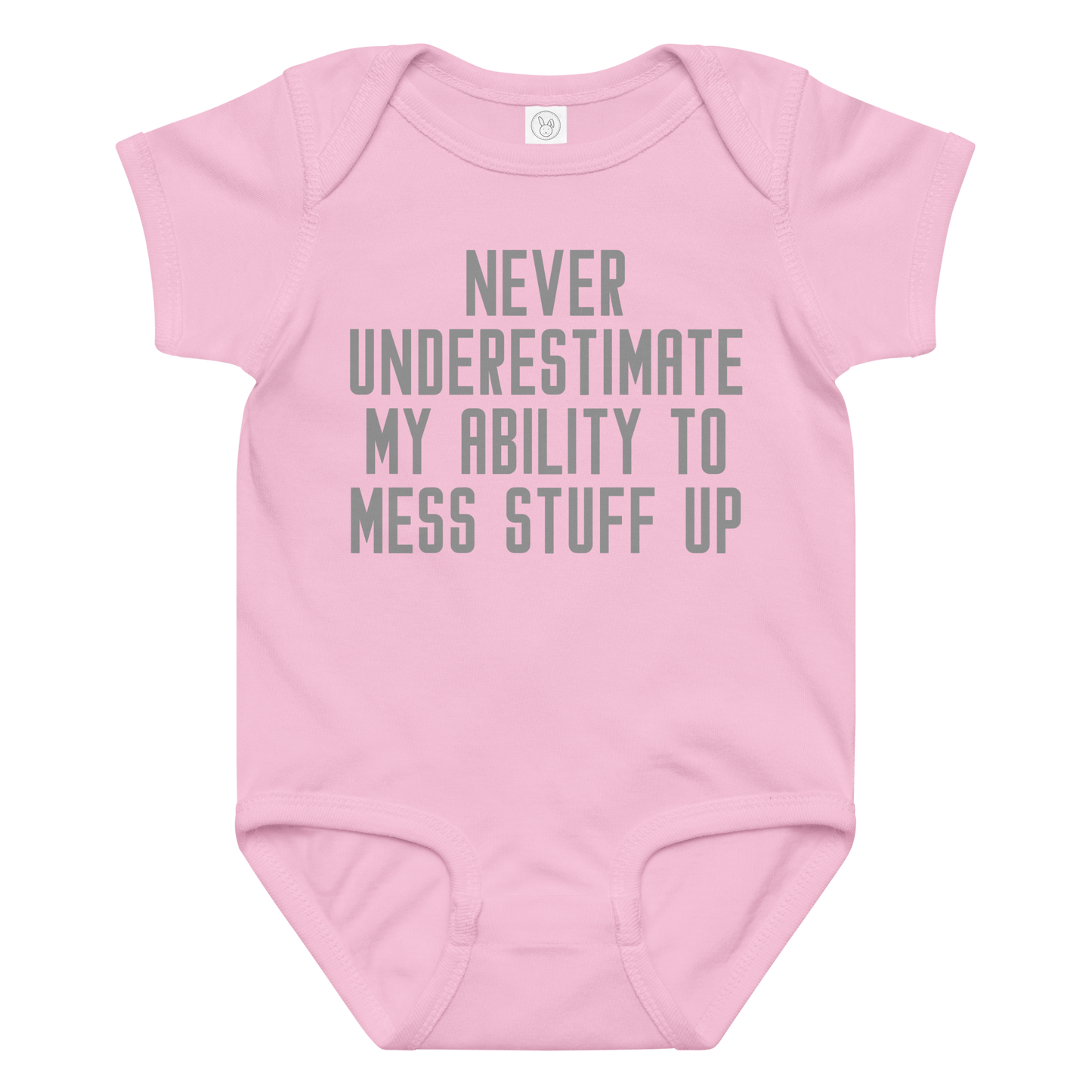 "Never Understimate My Ability To Mess Stuff Up" printed on a pink baby jersey bodysuit laying on a flat surface amongst other clothes